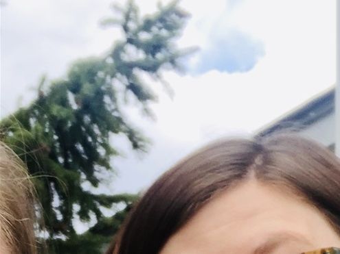 Megan smiling looking at camera holding a plant excitedly 